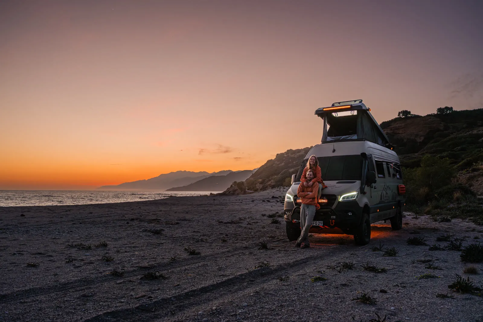 Wir beide vor dem Sprinter im Sonnenuntergang am Strand