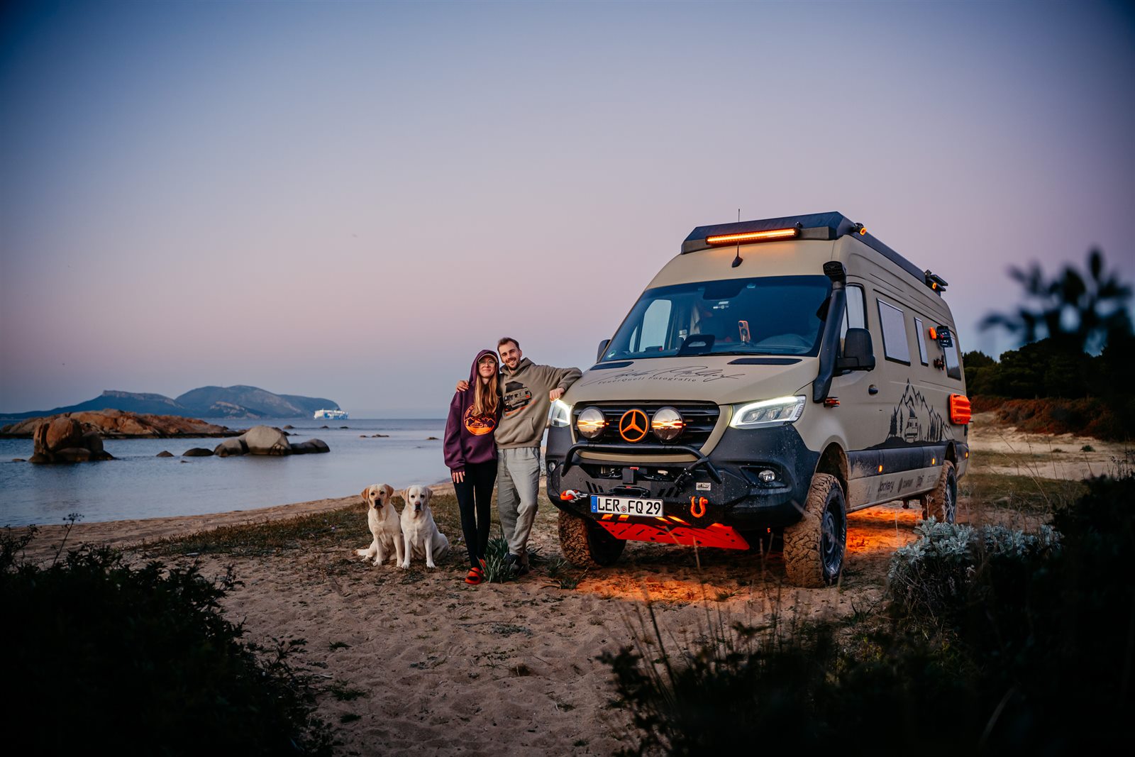 Jakob, Tomke und die beiden Hunde vor dem Sprinter am Strand